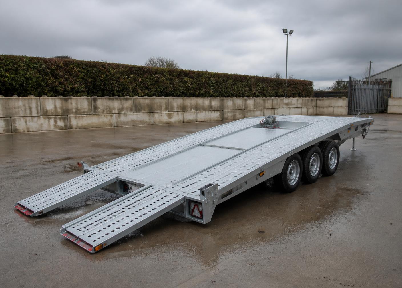 Tri-axle vehicle transporter trailer loaded with a car